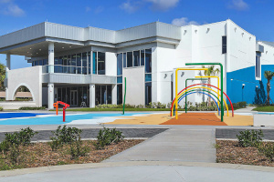 Cape Canaveral City Hall, a new building with a red tile roof,
                      an arched entrance and palm trees.