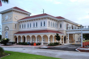 Cape Canaveral City Hall, a new building with a red tile roof,
                      an arched entrance and palm trees.